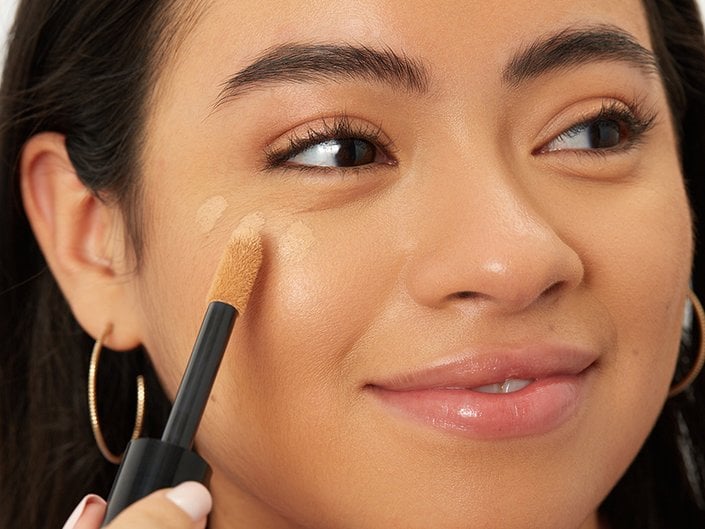 person applying concealer under eye