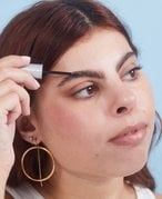 Person applying brow gel to their eyebrow