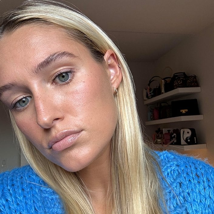 Editor with long blonde hair wearing a blue knit cardigan an everyday makeup look