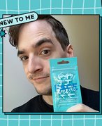 Picture of an editor holding the NYX Professional Makeup Face Freezie Reusable Cooling Under-Eye Patches, on a blue and white checked graphic background