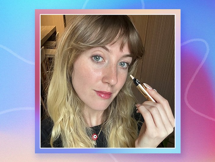 Picture of the editor holding the YSL Beauty Touche Éclat All-Over Brightening Pen on a graphic, multicolored background