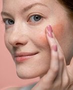 Photo of a person showing how to use lipstick as blush